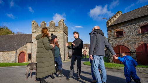 Staff talking with visitors at Castle Ward in the farmyard